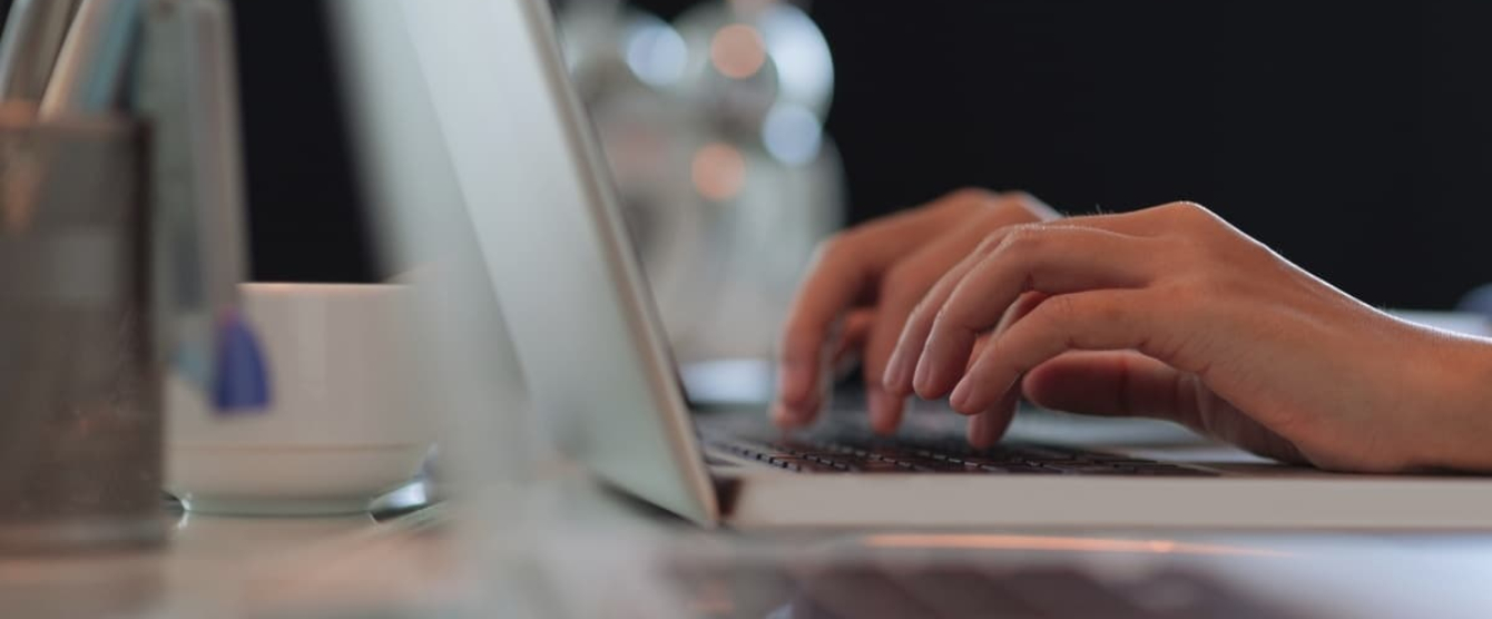 A person using a laptop computer on a table