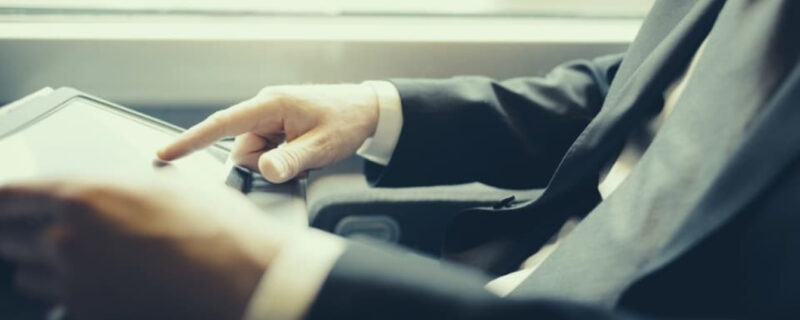 A man in a suit and tie looking at a computer