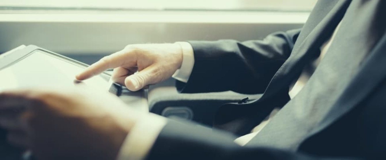 A man in a suit and tie looking at a computer