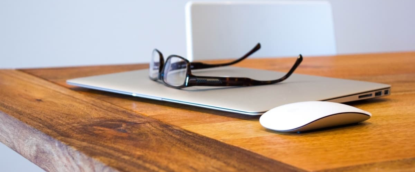 A laptop computer sitting on top of a wooden table