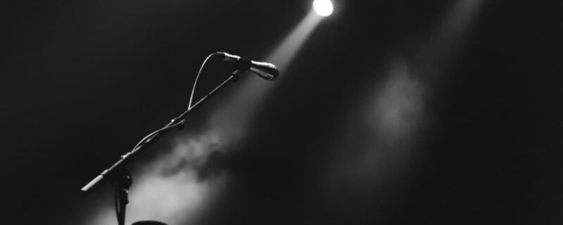 A black and white photo of a microphone with a light shining on it