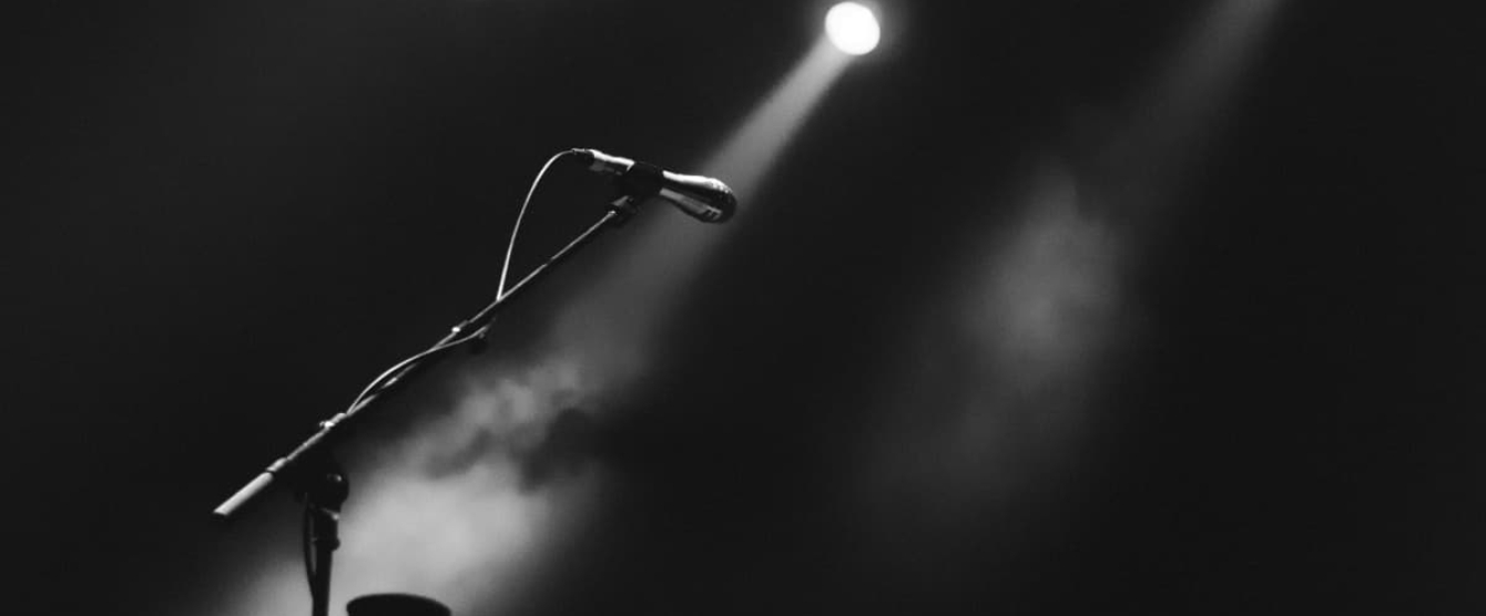 A black and white photo of a microphone with a light shining on it