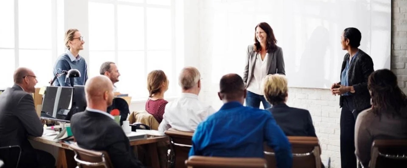 People sitting in a room with someone giving a presentation