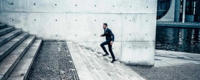 A man in a suit running up stairs
