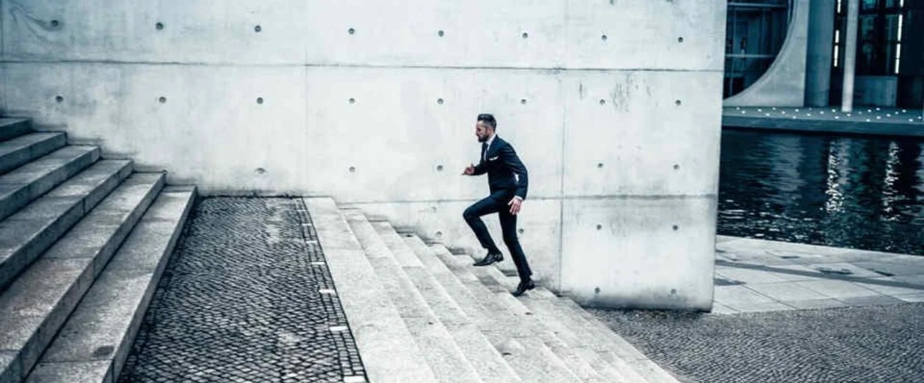 A man in a suit running up stairs