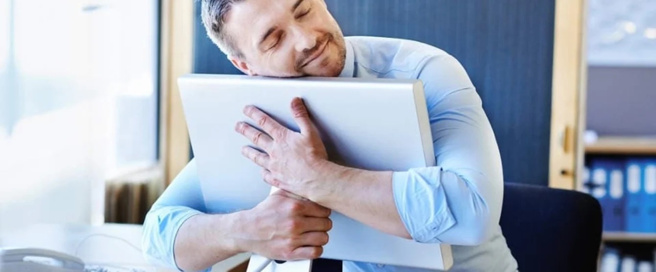 A man hugging  a computer monitor