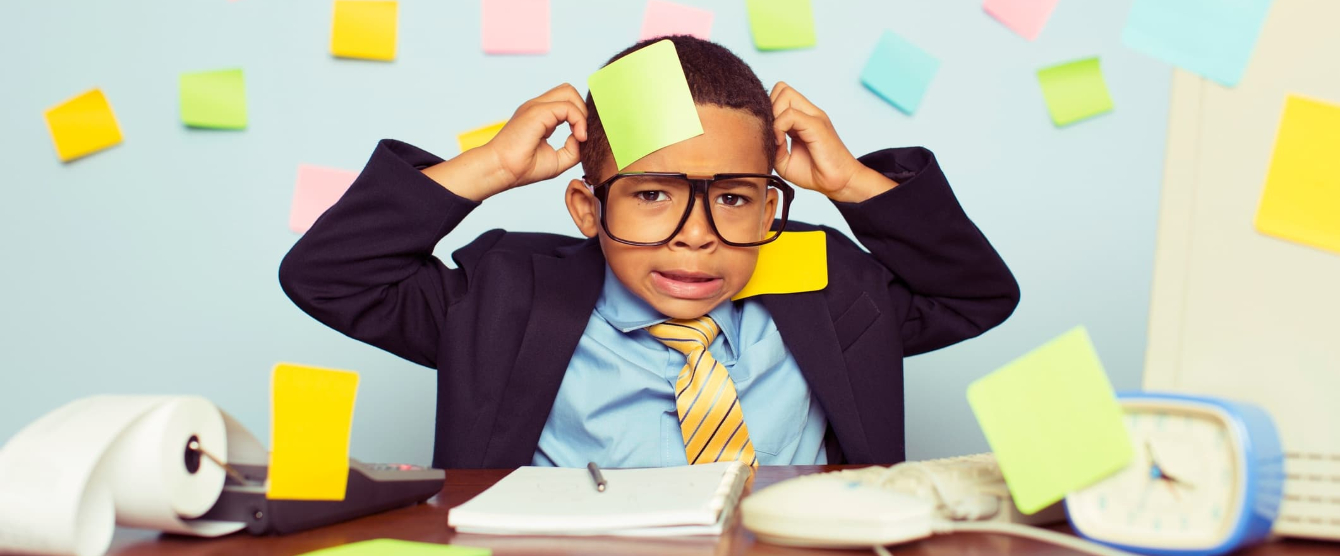 A small child in a suit with post it notes flying everywhere