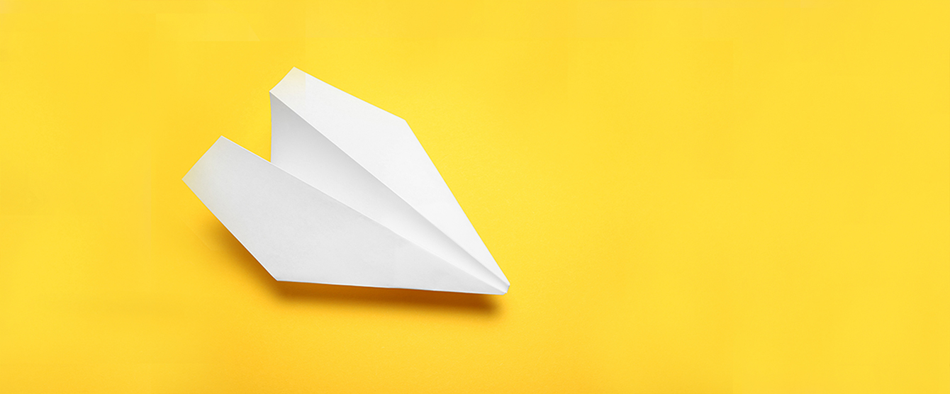 A paper airplane with a yellow background