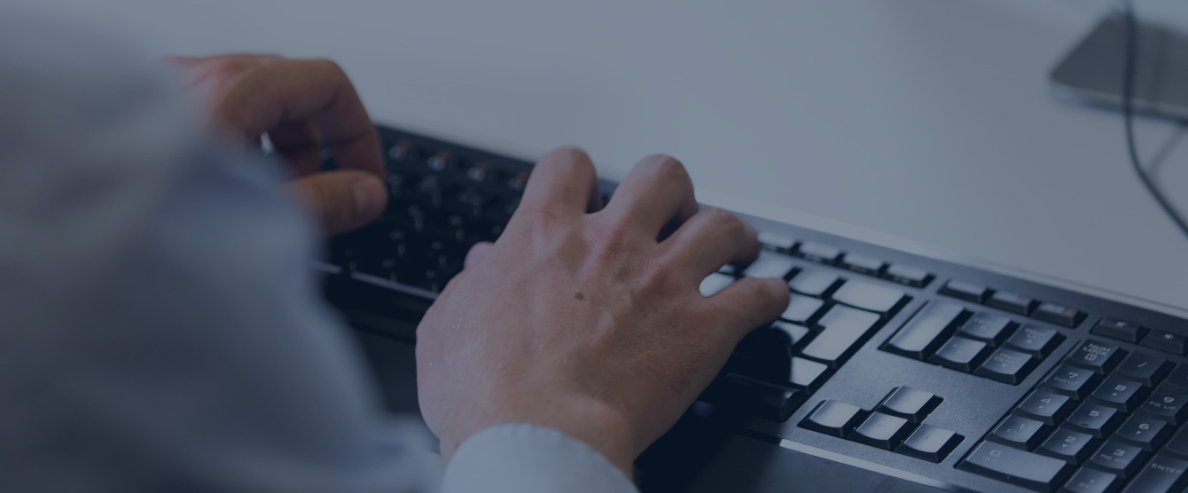 Hands typing on a computer keyboard