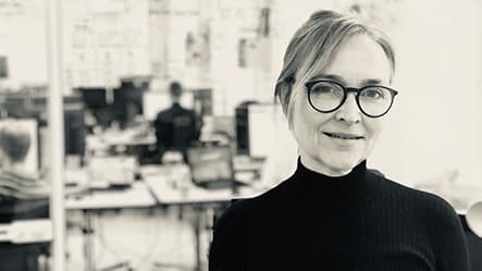 A women in glasses with a black shirt smiling