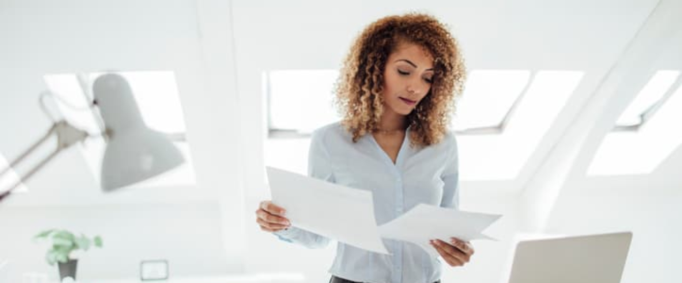 A woman in a white shirt looking at documents