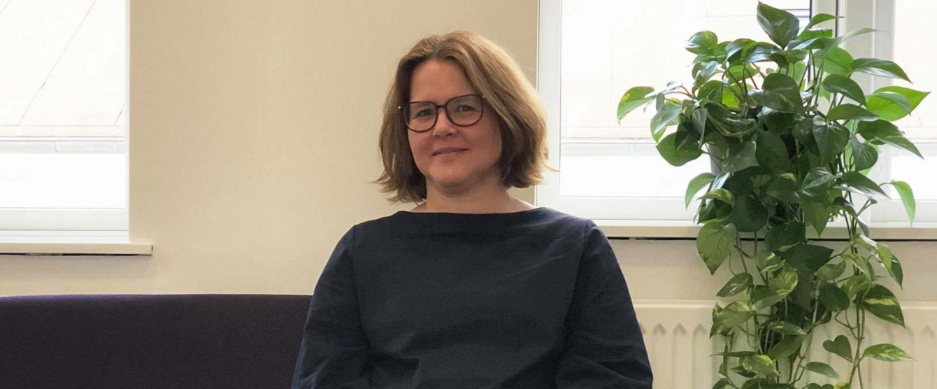 A woman with glasses and a black shirt posing for a picture