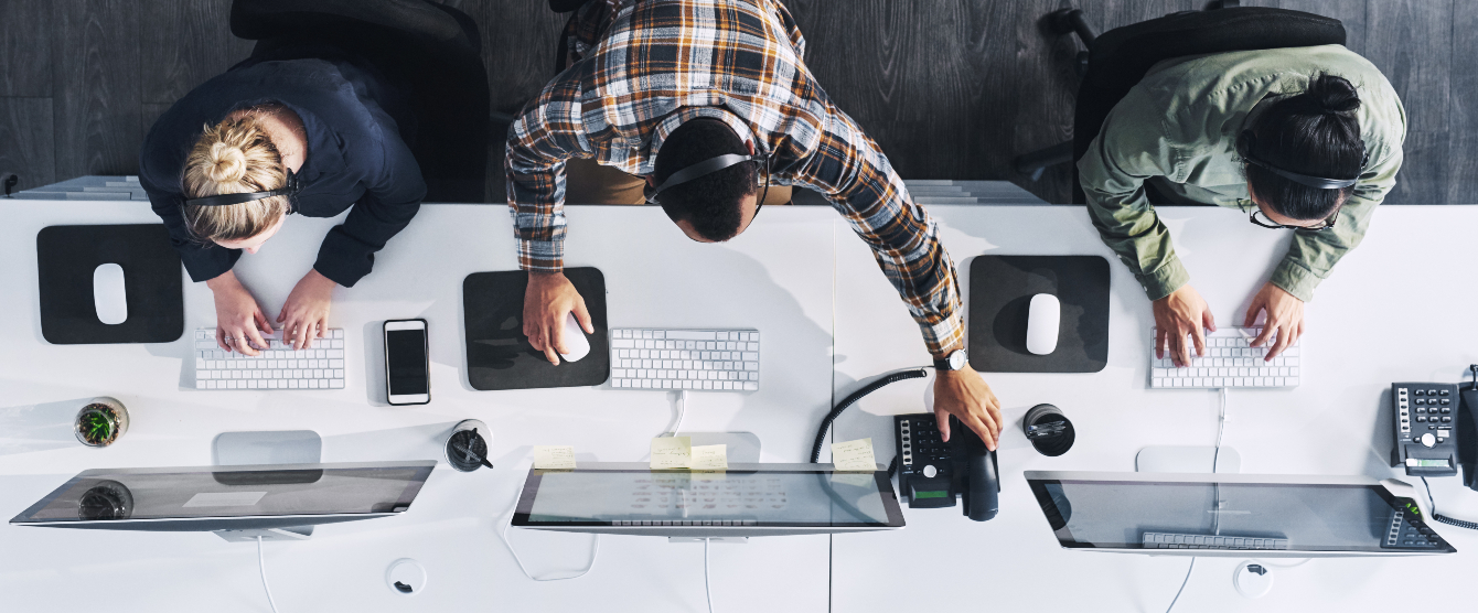 Top view of three people working on a computer