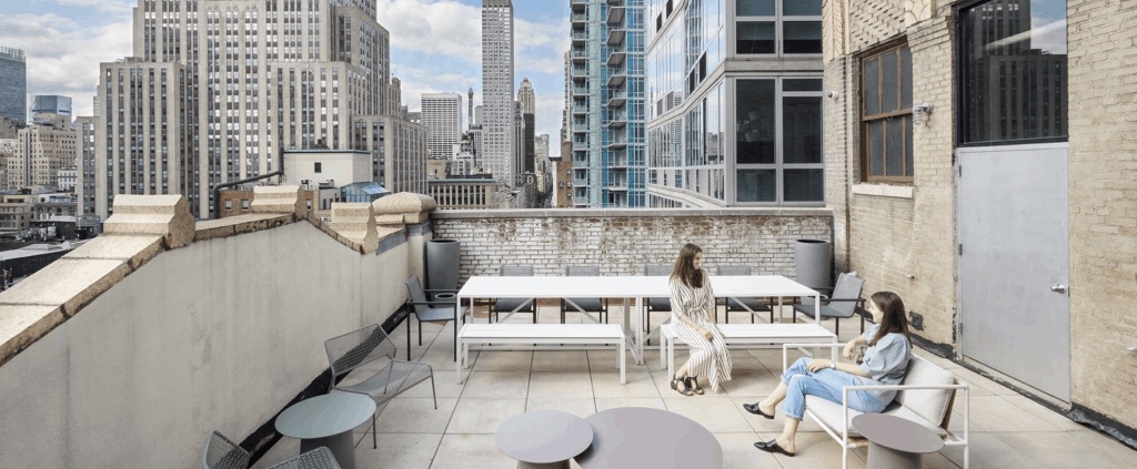 Two people talking on a city balcony