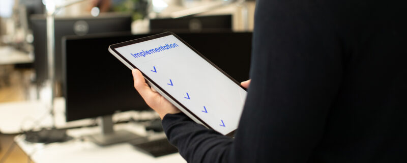 A person holding a tablet with checkmarks on the screen