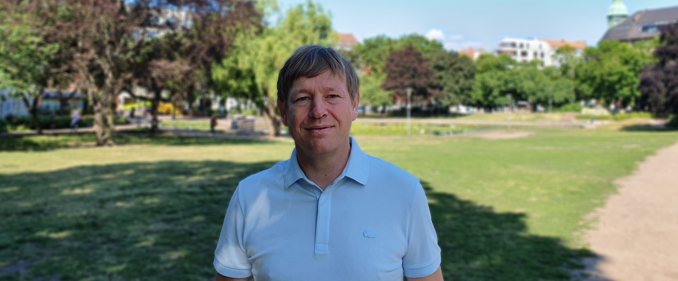 A man outside posing for a picture